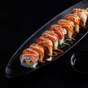 Lachs Sushi Rolle auf einer schwarzen Platte