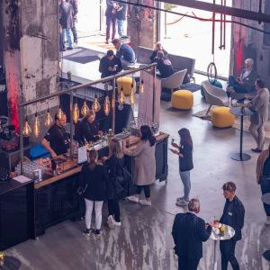 Mobile Bar in einem fabrikähnlichen Veranstaltungsraum mit Gästen bei einem Business Event