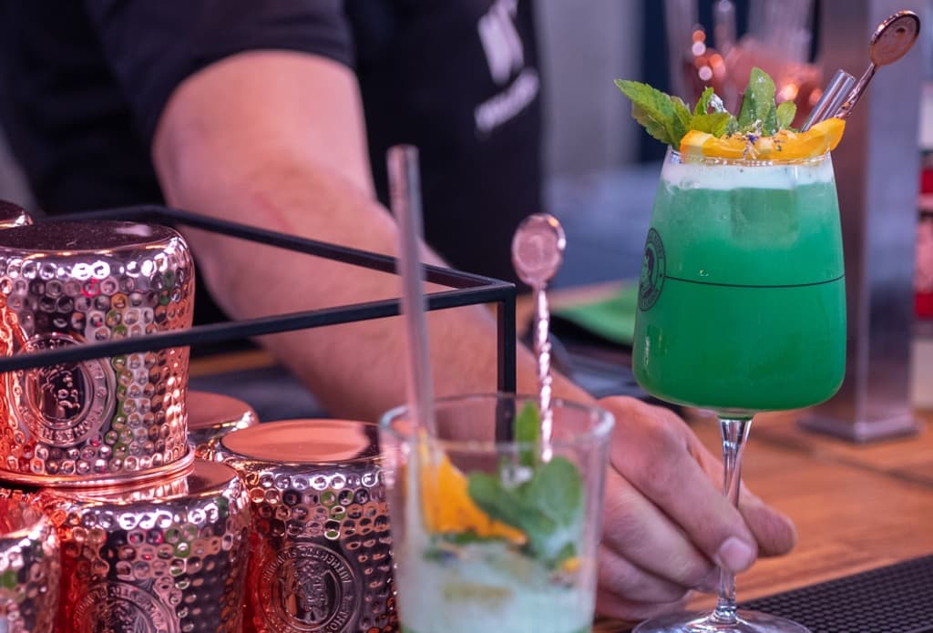 grünfarbener Cocktail wird serviert