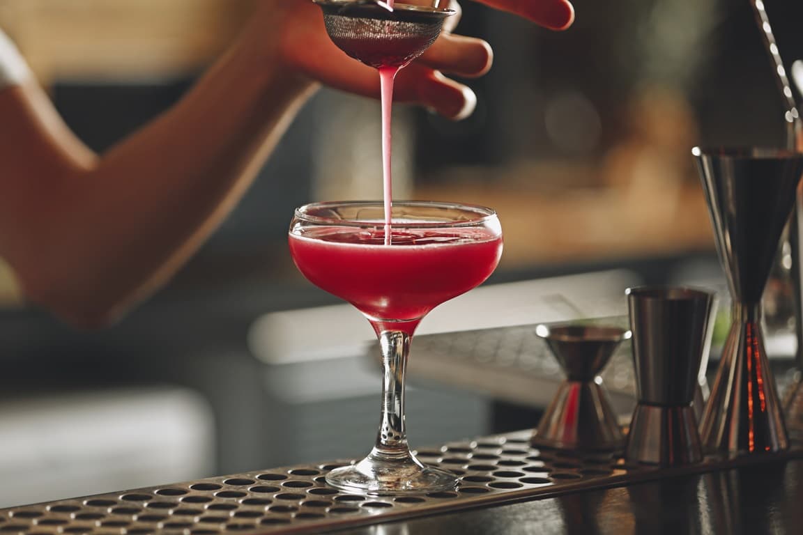 Barkeeper mixed einen Cocktail auf der Theke