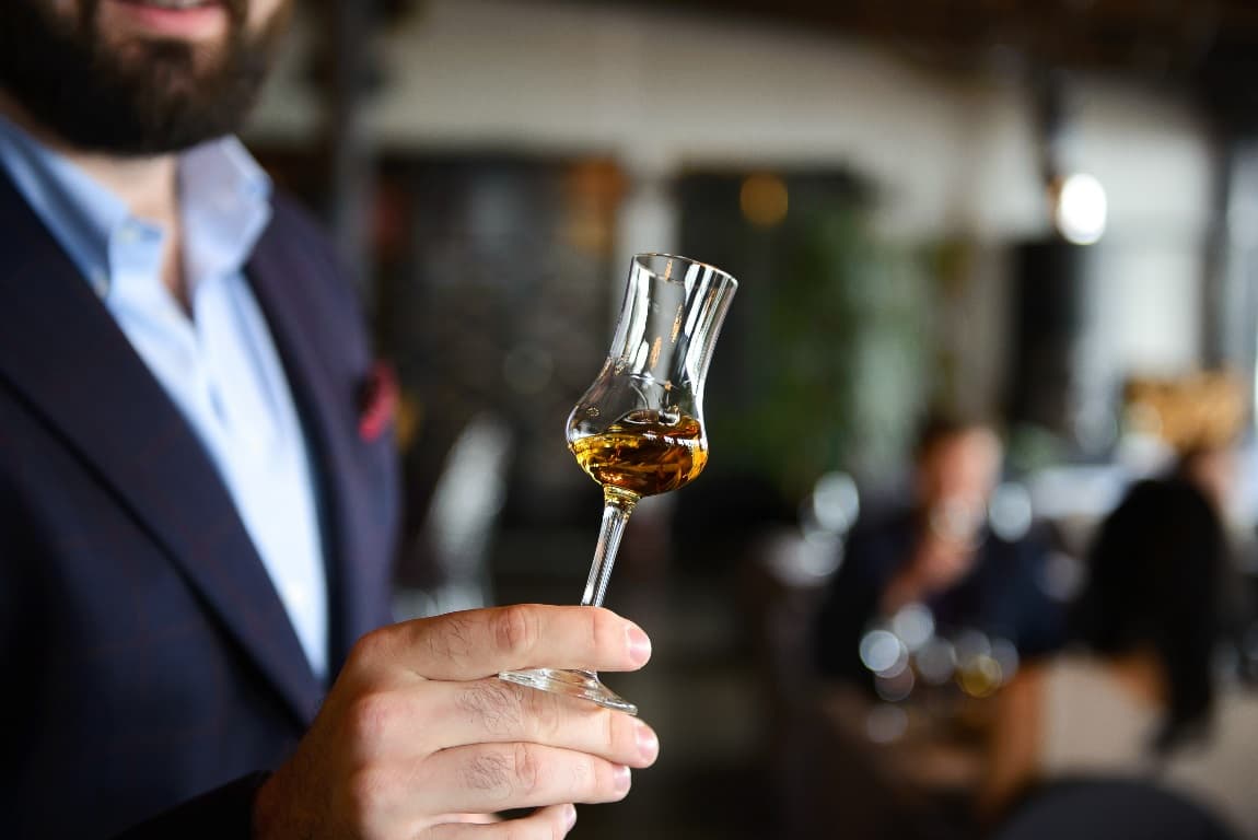 Ein Mann mit einem Glas Whisky beim Tasting